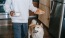 a dog and a person holding a plate of food
